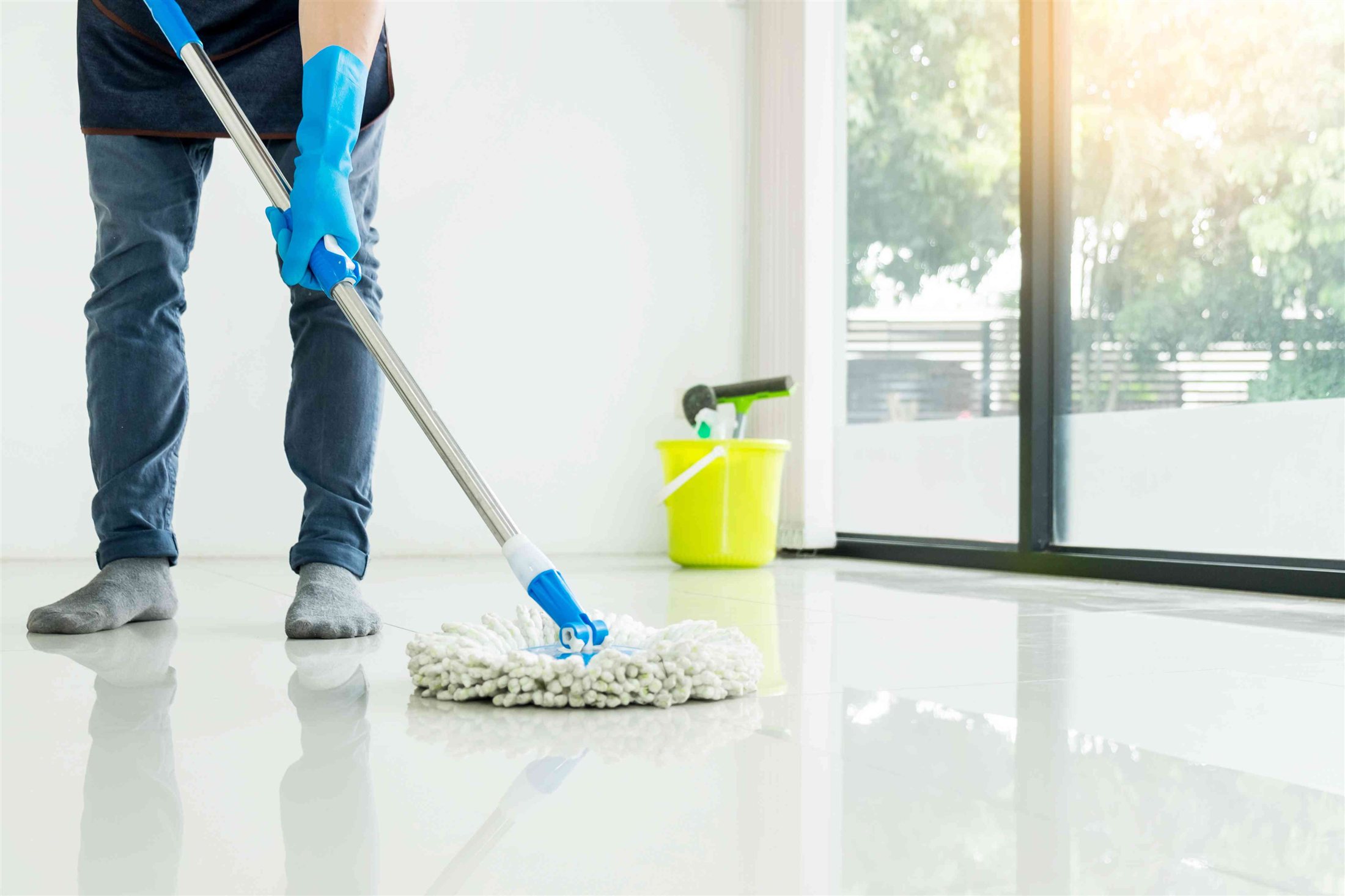 Cleaner mopping a bright floor